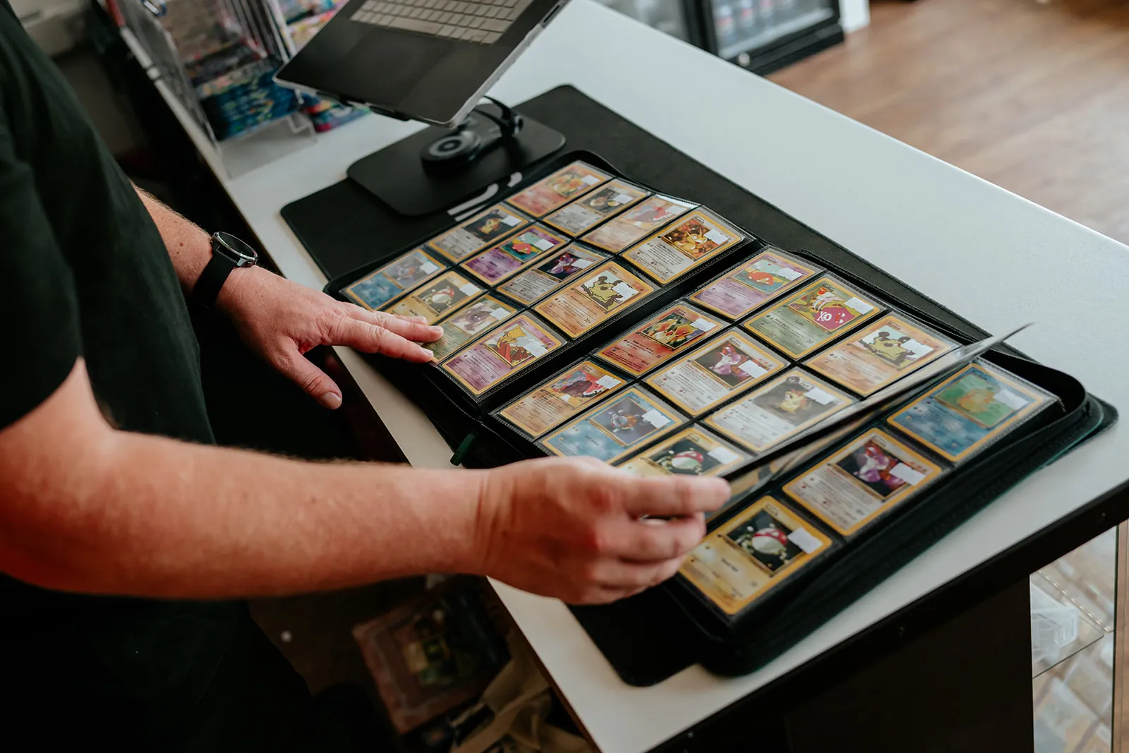 Browsing through a binder of cards at the counter at Card Guys